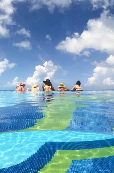 Mujeres jóvenes se divierten en la piscina infinita del hotel en el mar Caribe. Concepto de vacaciones y despedida de soltera en la piscina —  Fotos de Stock