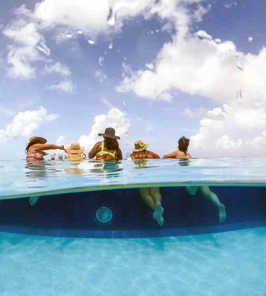 Μισή υποβρύχια χωρισμένη εικόνα νεαρών γυναικών που διασκεδάζουν στην πισίνα του ξενοδοχείου στην Καραϊβική θάλασσα. Έννοια των διακοπών και bachelorette πισίνα κόμμα — Φωτογραφία Αρχείου