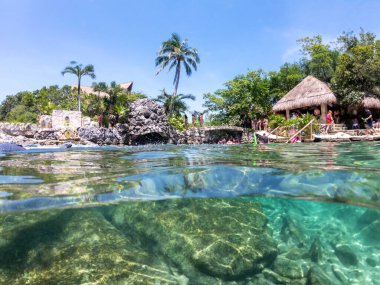 Cancun, Meksika - 13 Eylül 2021: Maya Riviera tatil beldesi XCaret parkındaki Snorkeling lagünündeki bölünmüş sualtı manzarası. XCaret, Meksika Mayan Riviera 'sında ünlü bir eko-turizm parkı.