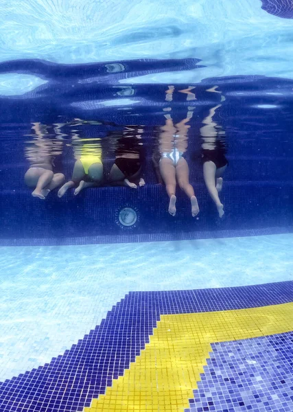 Underwater view of young women having fun in hotel pool. Concept of vacation and bachelorette pool party — Stock Photo, Image