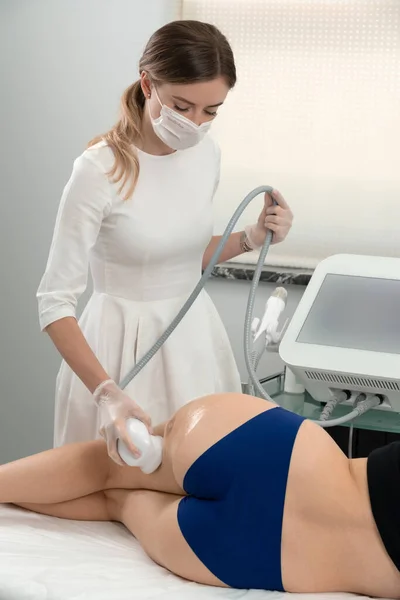 Ultrasound cavitation body contouring treatment. Woman getting anti-cellulite and anti-fat therapy in beauty salon