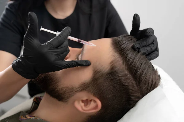 Inyecciones de belleza en la cara masculina joven. Suavizado de imitar arrugas utilizando biorevitalización para el hombre — Foto de Stock