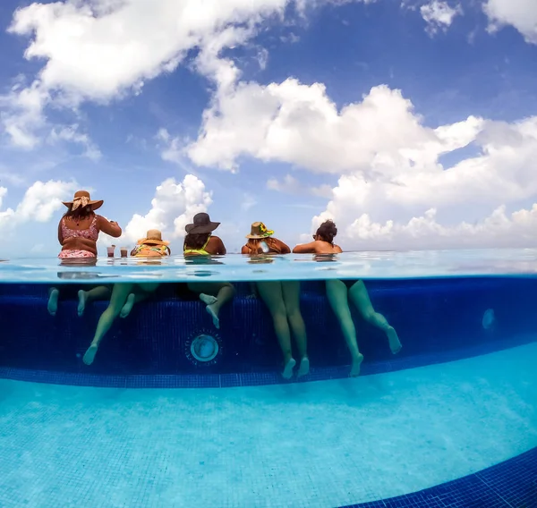 Media imagen dividida bajo el agua de mujeres jóvenes divirtiéndose en la piscina del hotel en el mar Caribe. Concepto de vacaciones y despedida de soltera en la piscina —  Fotos de Stock