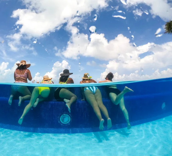 Hälften undervattensbild av unga kvinnor som har roligt i hotellpoolen i Karibiska havet. Begreppet semester och möhippa pool part — Stockfoto