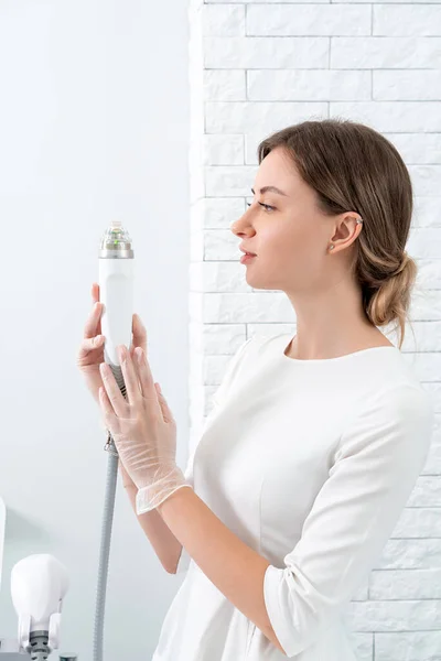Cosmetoloog met medische laserkop voor verjongende gezichts- en lichaamsbehandelingen — Stockfoto