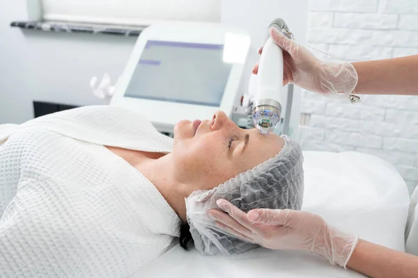 Dojrzała kobieta leczona laserowo w klinice kosmetologii — Zdjęcie stockowe