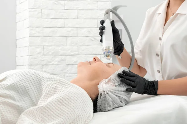 Mujer joven recibiendo tratamiento con láser en clínica de cosmetología — Foto de Stock