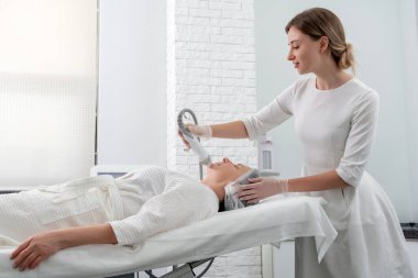 Olgun kadın kozmetoloji kliniğinde lazer tedavisi görüyor.