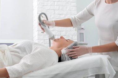 Olgun kadın kozmetoloji kliniğinde lazer tedavisi görüyor.