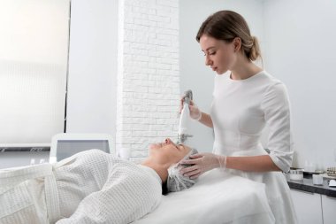 Olgun kadın kozmetoloji kliniğinde lazer tedavisi görüyor.