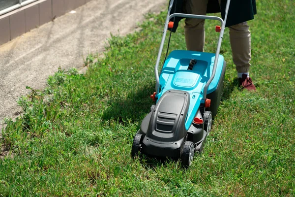 Man mowing the grass with an electric lawnmower — Stock Photo, Image