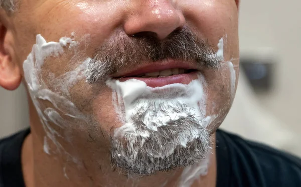 Středního věku pohledný muž holení jeho vousy v koupelně — Stock fotografie