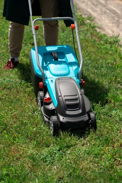 Man mowing the grass with an electric lawnmower — Stock Photo, Image
