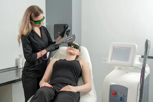 Młoda kobieta leczona laserowo w klinice kosmetologii — Zdjęcie stockowe