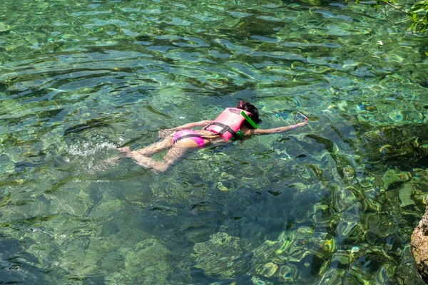 Chica con chaleco salvavidas haciendo snorkel en agua clara del océano — Foto de Stock