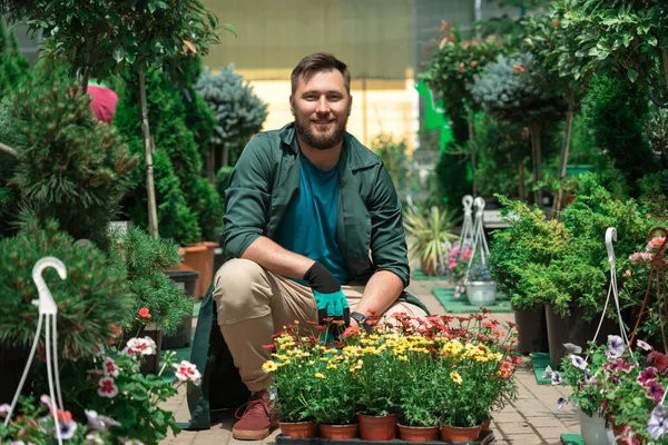 Jardineros trabajando con flores en el centro del jardín — Foto de Stock