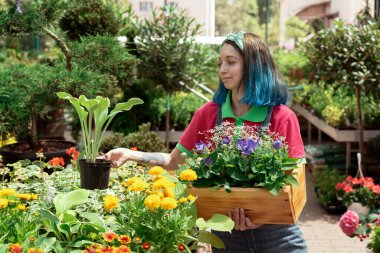 Florist working and arranging flower pots in garden store