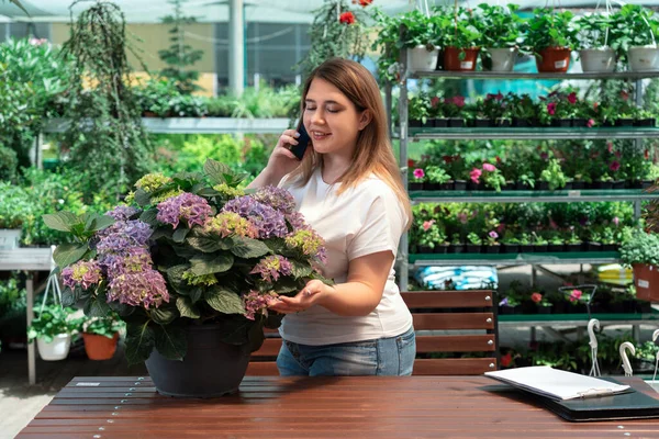 Portrait of garden center manager working with flowers for sales