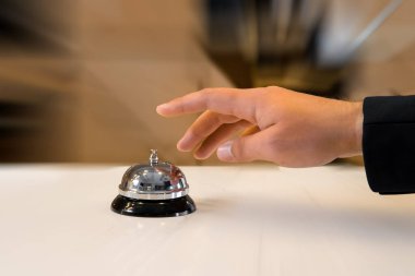 Eski bir otel çanı kullanan bir adamın eli.