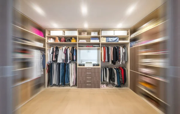 Big wardrobe with different clothes for dressing room. Walk in closet