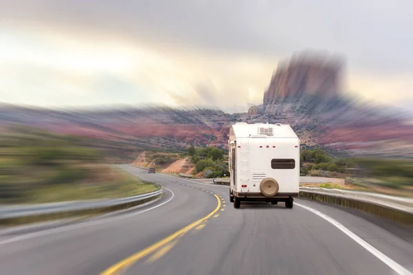 White Colour Motorhome Car Goes On Road On Background Of Mountains