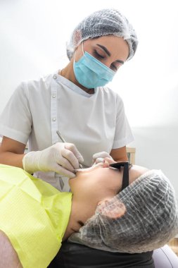 Dentist Examining Patients Mouth with dental mirror In Clinic. Checkup concept