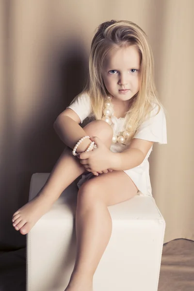 Pretty  blond little girl in a white short dress — Stock Photo, Image