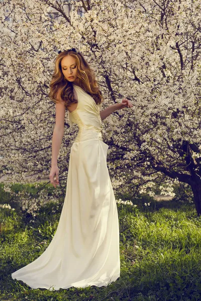 Beautiful girl with red hair posing at the spring blossom park — Stock Photo, Image