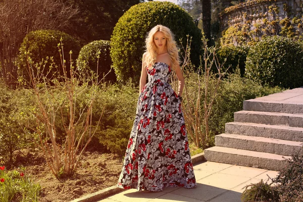 Красива блондинка в елегантній сукні позує в парку — стокове фото