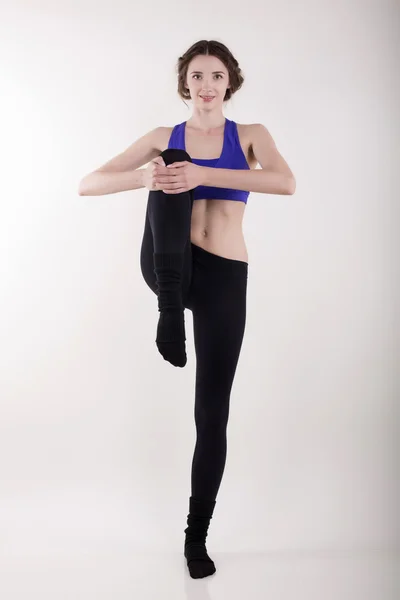 Vacker kvinna att göra stretching på vita studio — Stockfoto