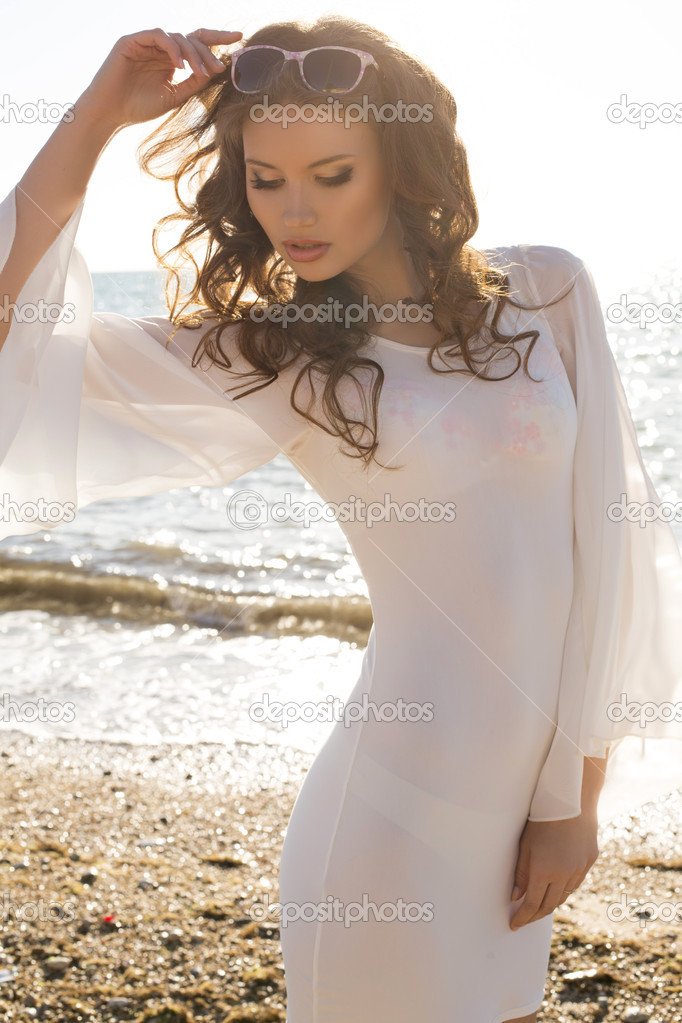 beautiful girl in white dress posing on the beach