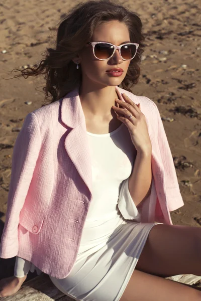 Schönes Mädchen im weißen Kleid posiert am Strand — Stockfoto