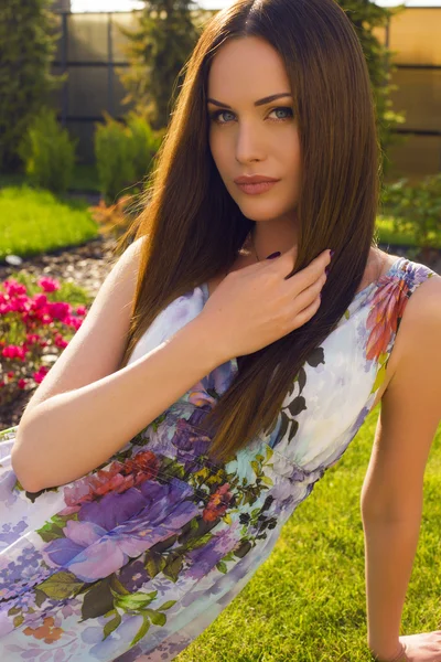 Hermosa mujer con cabello oscuro y ojos azules posando en el jardín de verano — Foto de Stock