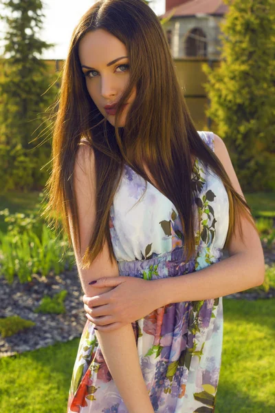 Hermosa mujer con cabello oscuro y ojos azules posando en el jardín de verano — Foto de Stock