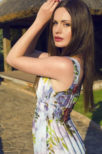 Beautiful woman with dark hair and blue eyes posing at summer garden — Stock Photo, Image