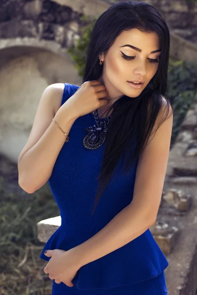在雅致的蓝色连衣裙的黑头发的漂亮女孩 — 图库照片