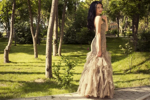 Belle femme élégante en robe de luxe posant au parc — Photo