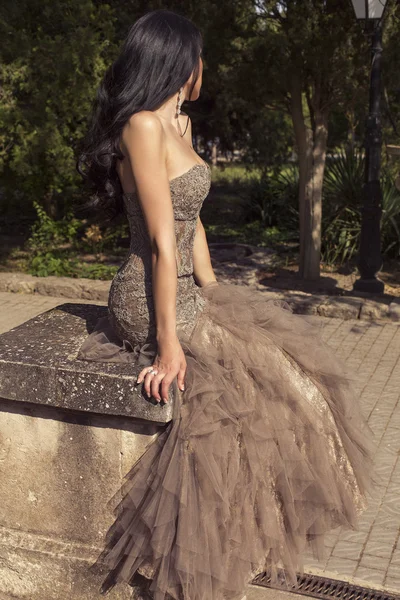 Beautiful glamour woman in luxurious dress posing at park — Stock Photo, Image