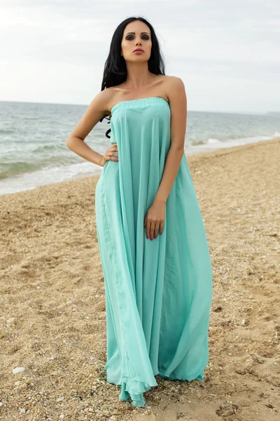 Sexy schöne Frau in elegantem Kleid posiert am Strand — Stockfoto