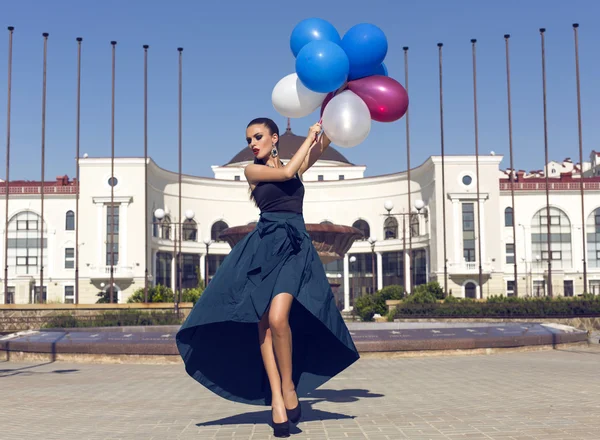 Belle femme en robe de luxe avec des ballons colorés — Photo