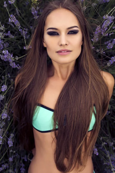 Sexig tjej med långt rakt hår i bikini poserar på lavendel — Stockfoto