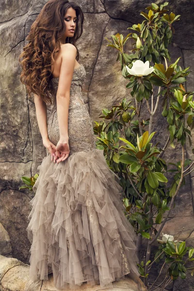 Beautiful woman with long curly hair  in luxurious dress — Stock Photo, Image