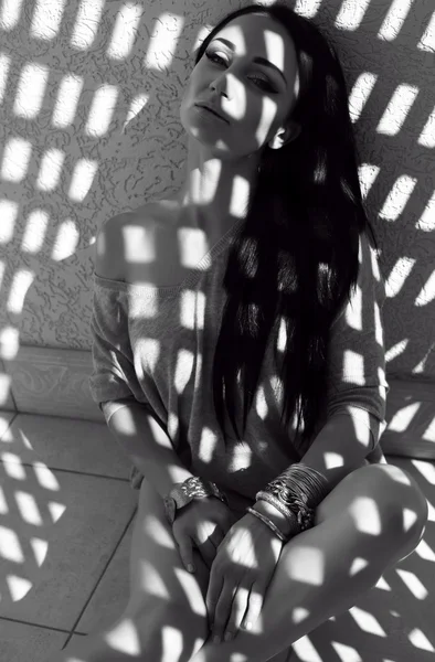 Vacker kvinna med svart hår poserar på solljuset strålar — Stockfoto