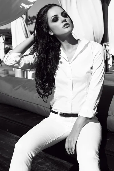 Sexig tjej med långt mörkt hår i vit skjorta och byxor — Stockfoto