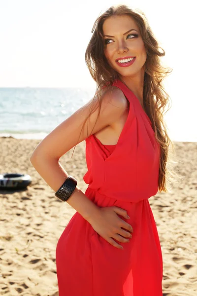 Bela menina sorridente com cabelo escuro em vestido elegante posando na praia — Fotografia de Stock