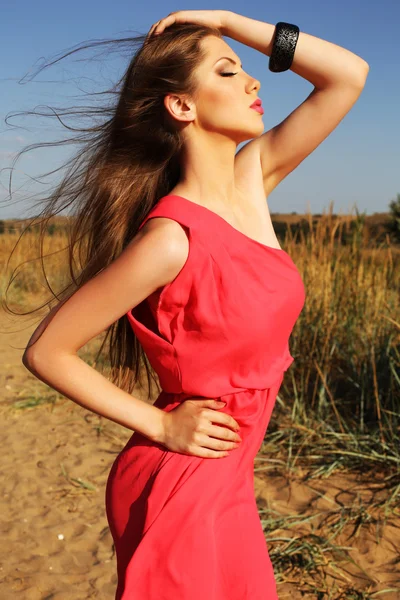 Mooi meisje met donkere haren in rode jurk — Stockfoto