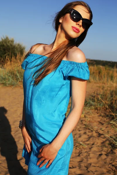 Vacker ung kvinna i blå klänning och solglasögon — Stockfoto