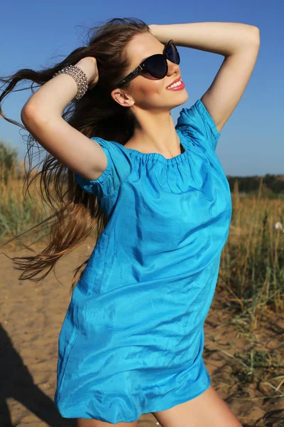 Schönes lächelndes Mädchen mit dunklen Haaren in elegantem Kleid und Sonnenbrille — Stockfoto