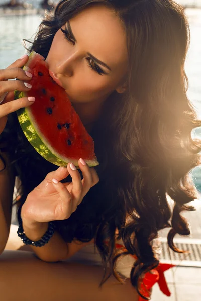 Sexy Mädchen mit dunklen Haaren isst Wassermelone — Stockfoto