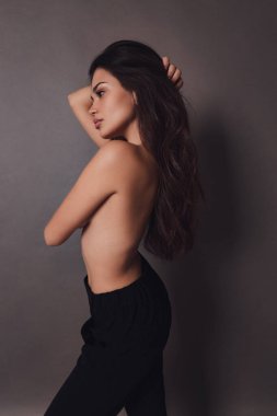 Stüdyoda poz veren siyah saçlı güzel bir kadının moda fotoğrafı.